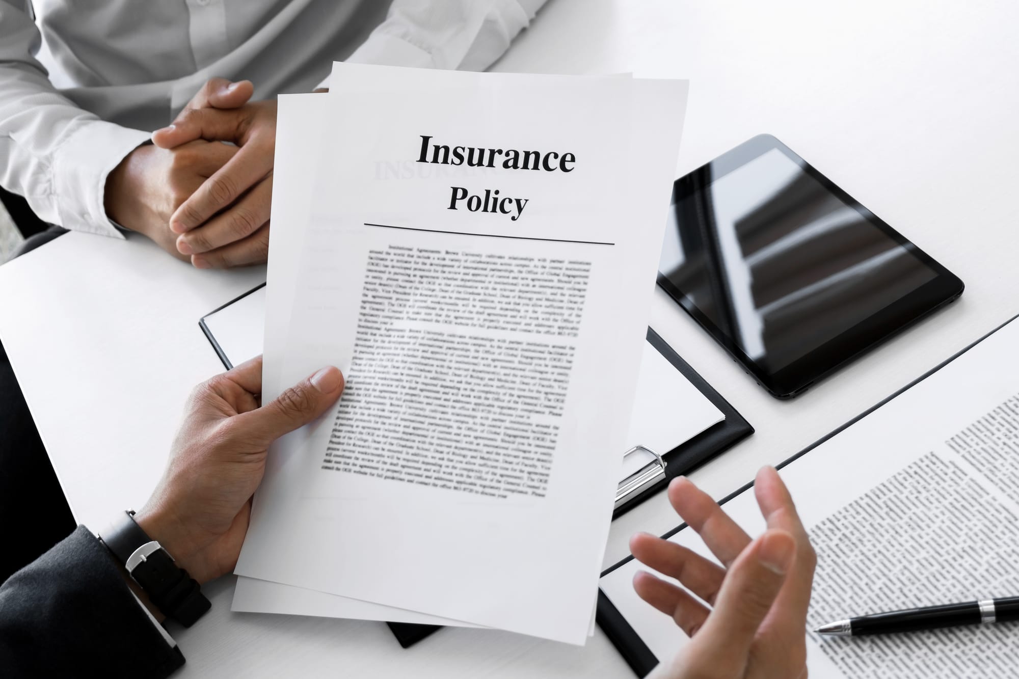 Insurance agent consulting with a customer about an insurance policy form.