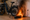 A black e-bike parked inside a home with the battery on fire.