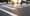 A blurred image of a group of people walking in a crosswalk with sun shining.