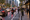A busy city street with cars, motorcycles, pedestrians, and bikes in a bike lane at dusk.
